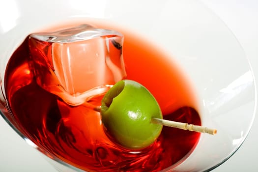 Martini glass with olive and ice cube