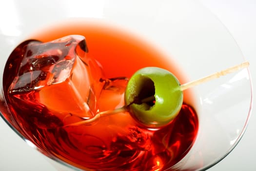 Martini glass with olive and ice cube