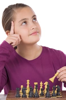 Attractive little girl playing chess