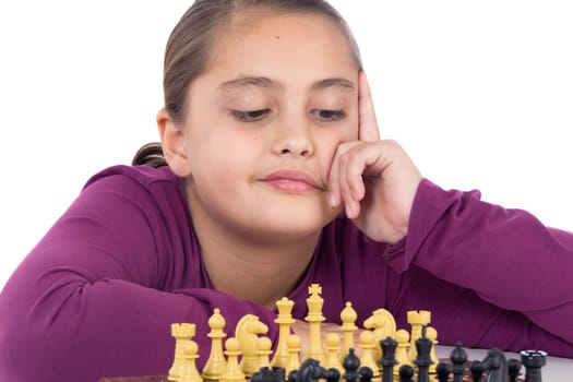 Attractive little girl playing chess