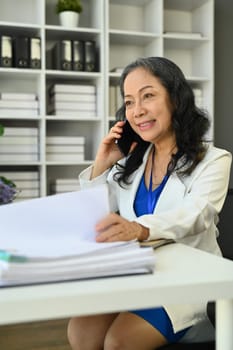 Attractive middle age businesswoman having nice conversation and looking aways.