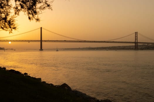 25th of April Bridge - Sunset over Tejo river in Lisbon. Mid shot