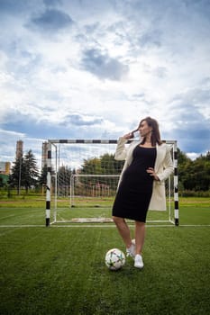 portrait of a beautiful woman football player in a strict office suit. concept sports office manager leisure