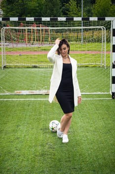 portrait of a beautiful woman football player in a strict office suit. concept sports office manager leisure