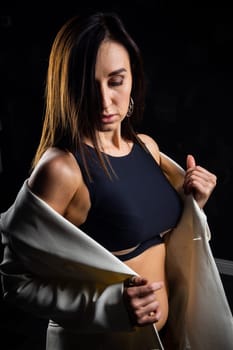 A business woman showing off her body in her underwear. Shot in the studio on a dark background.