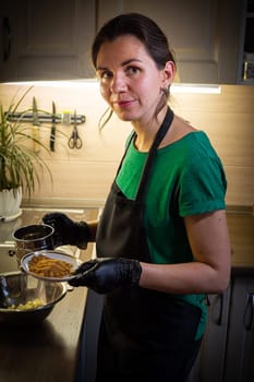 Woman cooking tasty melted chocolate on table in kitchen. Delicious dessert made of homemade chocolate.