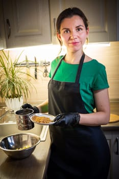 Woman cooking tasty melted chocolate on table in kitchen. Delicious dessert made of homemade chocolate.