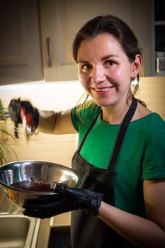 Woman cooking tasty melted chocolate on table in kitchen. Delicious dessert made of homemade chocolate.