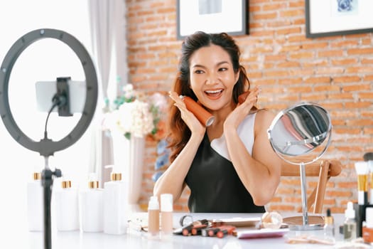 Woman influencer shoot live streaming vlog video review makeup uttermost social media or blog. Happy young girl with cosmetics studio lighting for marketing recording session broadcasting online.