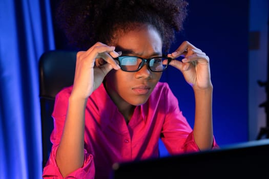 African woman businesswoman or blogger wearing pink shirt with serious face, looking and focusing on screen laptop with struggle project. Concept of stressful expression at work from home. Tastemaker.