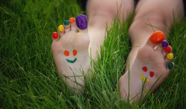 a smile painted with paints on the child's arms and legs. Selective focus