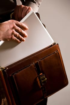 Businessman taking uot laptop from case