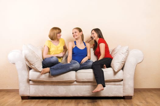 Three laughing women on a sofa
