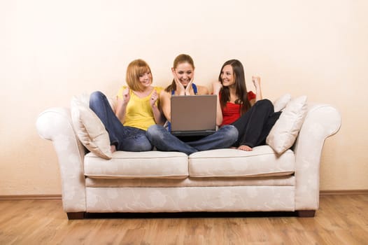 Three women on a sofa with laptop