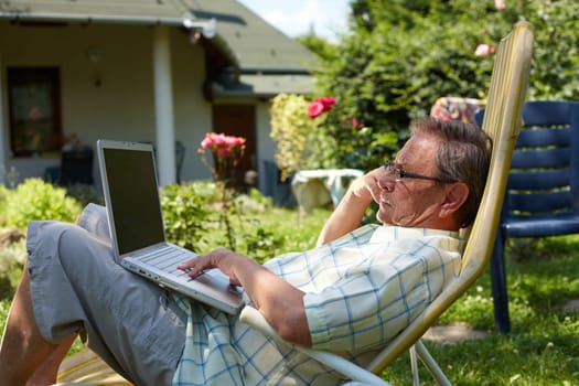 Senior man using laptop outdoor