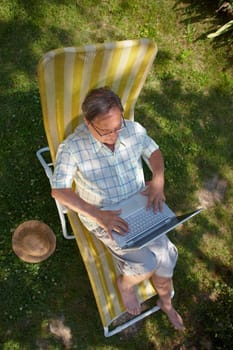 Senior man using laptop outdoor