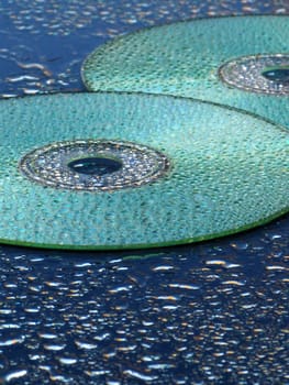 CD and water drops over blue background