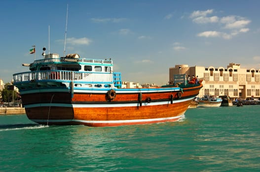 An empty dhow merchant ship sails upstream on the creek of Dubai,Verei