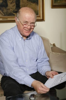 Cheerful senior at home with laptop