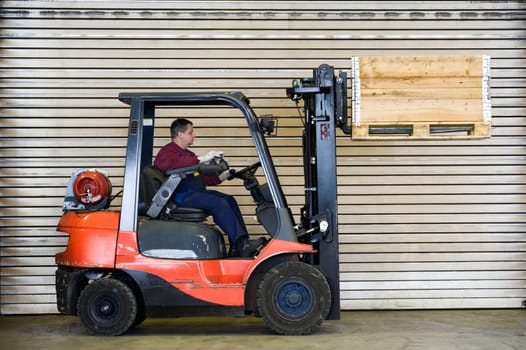 Man on forklift transports crate