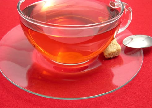 Teacup with rosehip tea on red placemat