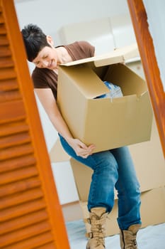 Young woman lifting cardboard box