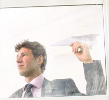 Businessman flies paper airplane.