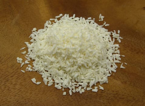 Coconut flakes on a brown wooden board