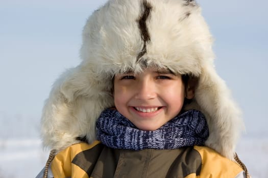 Smiling boy in the fur-cap