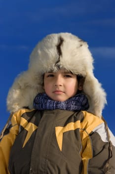 Boy winter portrait in the fur-cap