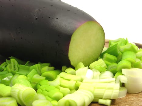 Eggplant and sliced spring onion on wooden board