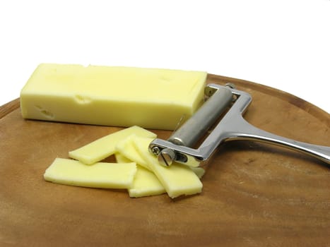 Hard cheese on wooden plate with cheese slicer