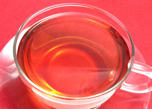 Teacup with rosehip tea on red placemat