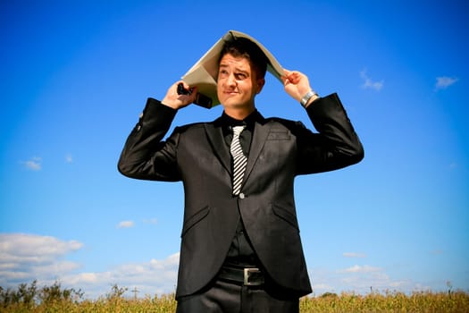 Worried businessman with folder above his head