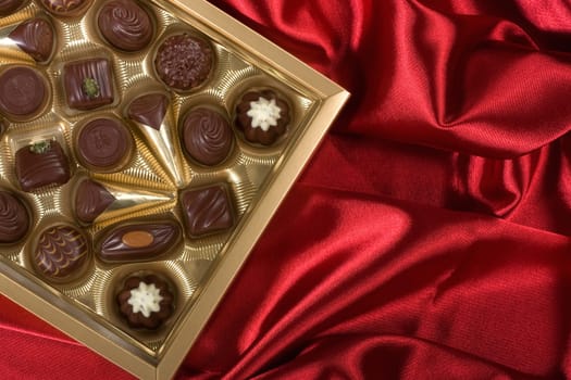 Golden chocolates box on red satin
