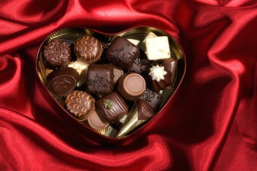 Heart Shaped Box of Candy on red satin