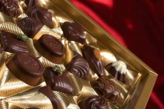 Golden chocolates box on red satin