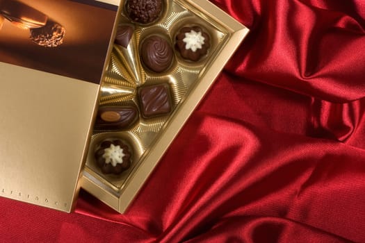 Golden chocolates box on red satin