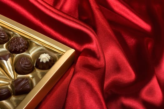 Golden chocolates box on red satin