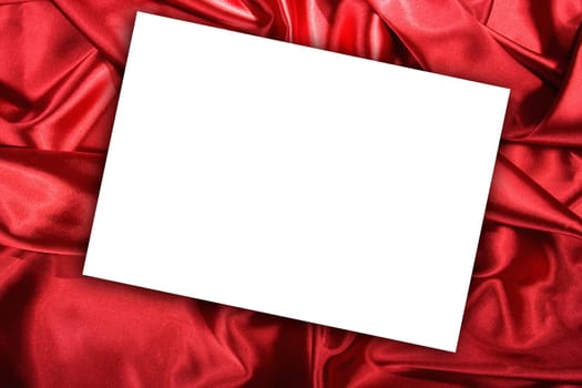 Blank white card on red colored satin