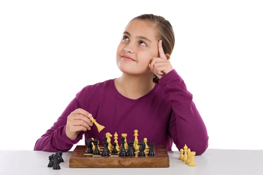 Attractive little girl playing chess