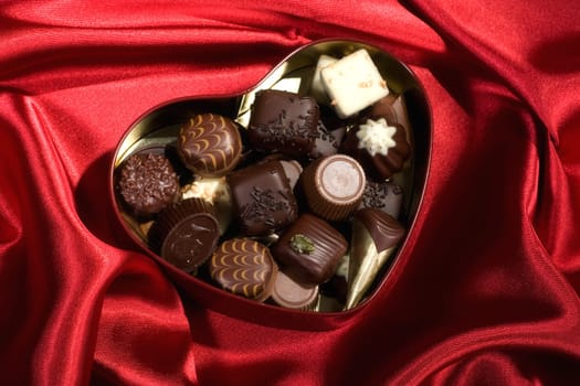 Heart Shaped Box of Candy on red satin