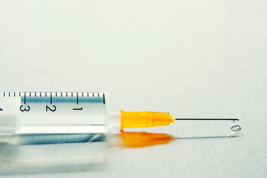 Drop of a liquid on a needle of syringe