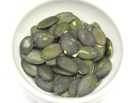 Pumpkin seeds in a white porcelain bowl