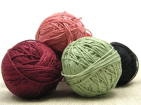 Wool ball in brown,yellow and red arranged against a checkered background