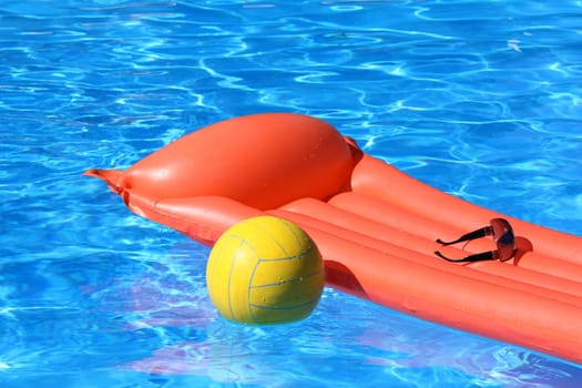 Air mattress and volleyball in the water