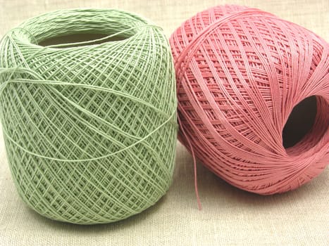 Wool ball in green and pink on beige background