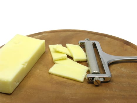 Hard cheese on wooden plate with cheese slicer