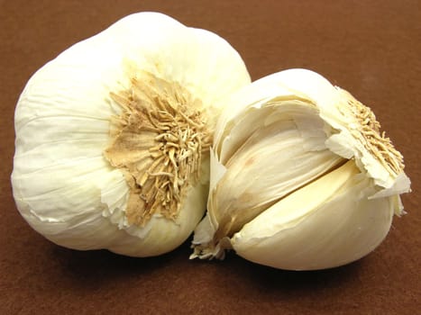 Garlic cloves arranged on a brown background