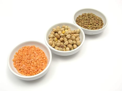 Three porcelain bowls with chickpeas,red and plate lentils